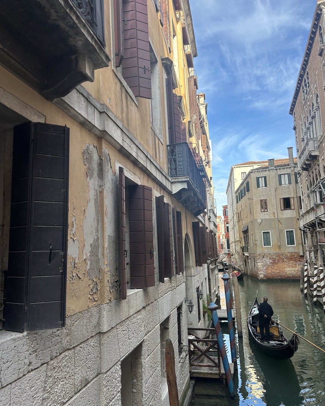 A canal in Venice, a gondola gliding between the façades